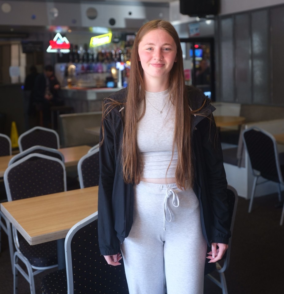 Young woman standing in a pub.