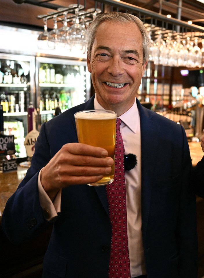 Nigel Farage and a Reform UK candidate holding pints of beer in a pub.