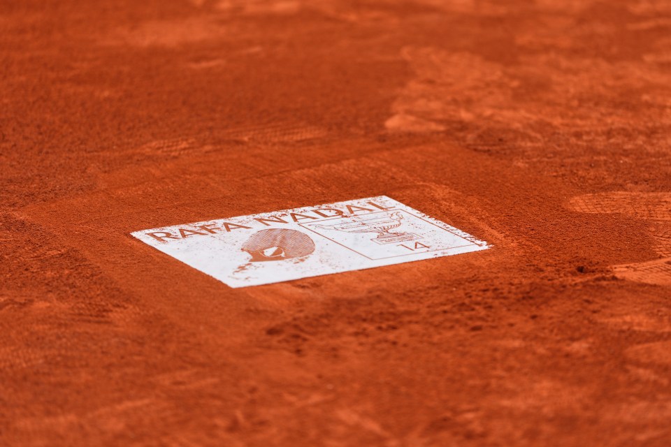 Footprint plaque for Rafa Nadal on a clay tennis court.