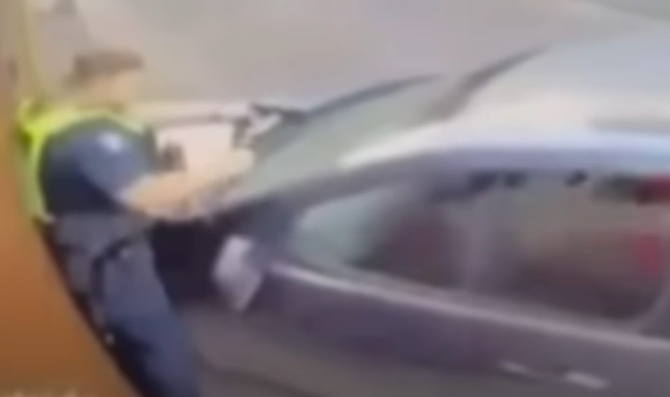 Blurry image of a police officer at a car.