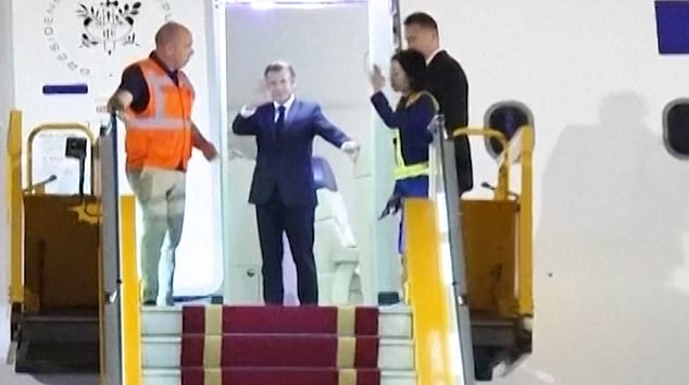 The president appears startled but quickly recovers and turns to wave through the open door