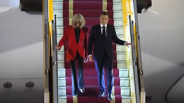 The couple then proceed down the staircase for the official welcome by Vietnamese officials, though Brigitte Macron does not take her husband's offered arm
