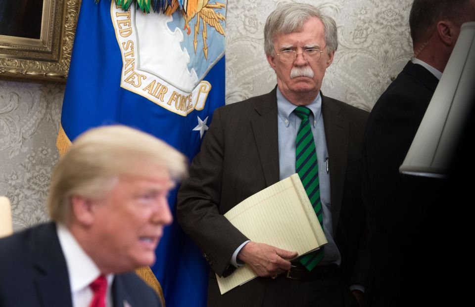John Bolton, National Security Advisor, holding a notepad.
