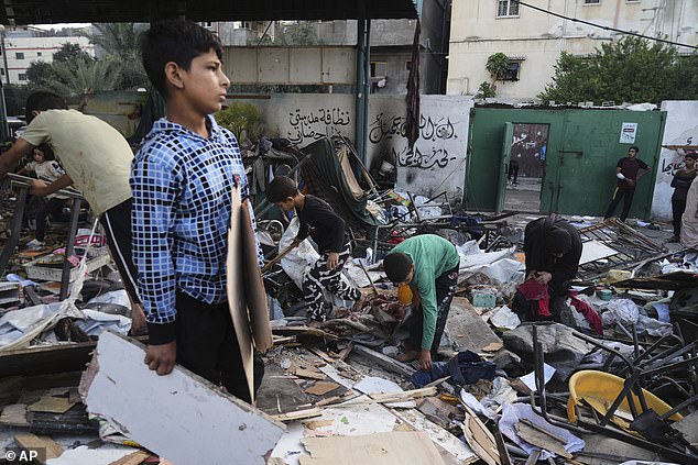 Palestinians inspect the damage at school used as a shelter by displaced residents that was hit by Israeli military strike and killed at least 36 people