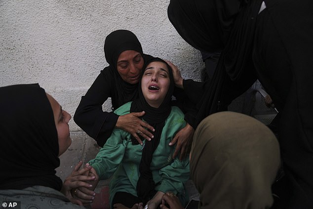 Walaa Al-Kilani, center, mourns her mother and brother, who were killed when an Israeli military strike hit a school sheltering displaced residents, at Al-Shifa Hospital in Gaza City