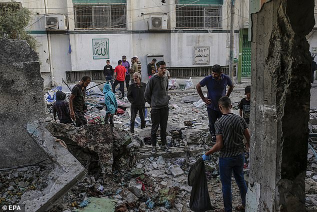 Palestinians inspect the rubble at the Al Jerjawi school following an Israeli airstrike in the Al Daraj neighborhood of Gaza City on May 26