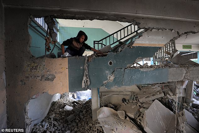 A Palestinian inspects the damage at a school sheltering displaced people, following an Israeli strike, in Gaza City, May 26