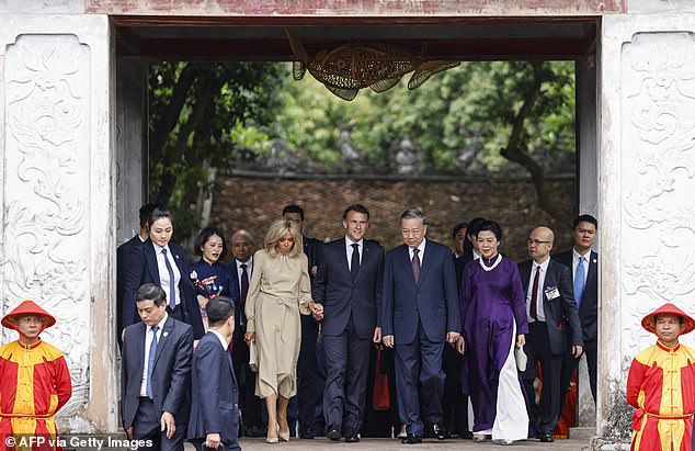 France's President Emmanuel Macron, his wife Brigitte Macron (C-L), Vietnam's General Secretary of the Communist Party To Lam and his wife Ngo Phuong Ly (C-R) visit the Temple of Literature in Hanoi on May 26