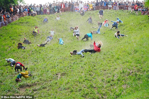Participants are seen tumbling down the hill in today's women's race in Brockworth