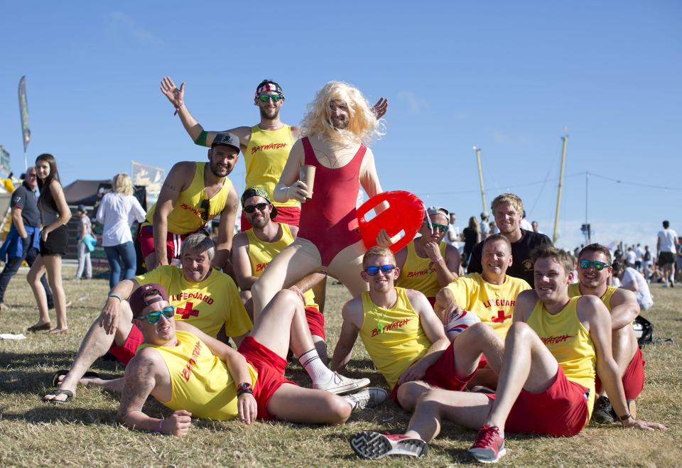 Group of men in Baywatch costumes at a festival.