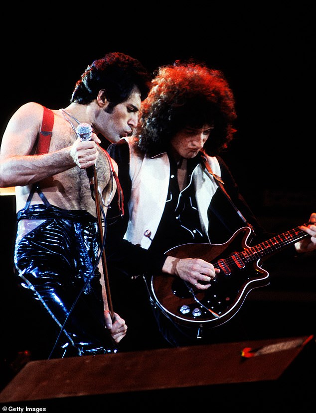 Freddie Mercury (left) is pictured here performing on stage at the Oakland Coliseum in California alongside Queen bandmate Brian May (right) on guitar in December 1978