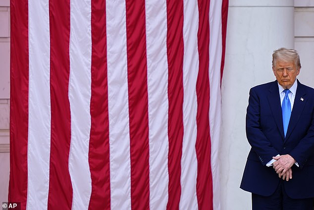President Donald Trump bows his head in prayer at the Memorial Day ceremony Monday at Arlington National Cemetery