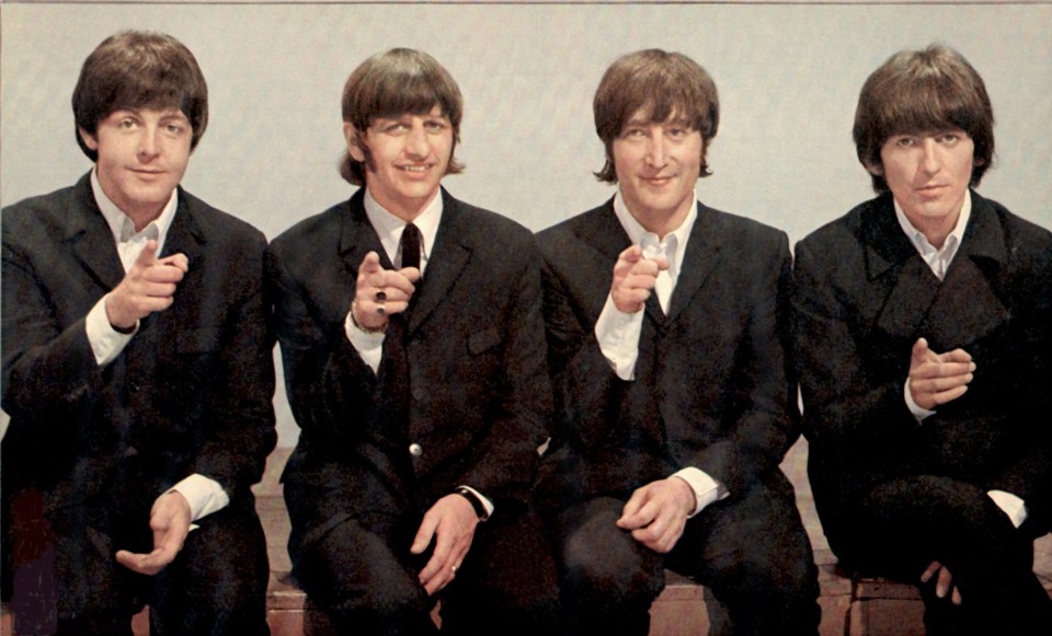 The Beatles pointing at the camera.