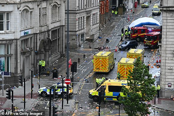 Police officers cover with an inflatable tent, behind a firefighter vehicle, the tents delimiting the scene of an incident in Water Street, on the sidelines of an open-top bus victory parade for Liverpool's Premier League title win, in Liverpool, north-west England on May 26, 2025. A car collided with a number of pedestrians in Liverpool, northern England, on May 26 evening during Liverpool FC's Premier League victory parade, police said. Police said they were contacted shortly after 6pm (1700 GMT) 'following reports of a collision between a car and a number of pedestrians' in the city centre. One man has been arrested, according to the police, who did not say whether there were any casualties. (Photo by Paul ELLIS / AFP) (Photo by PAUL ELLIS/AFP via Getty Images)