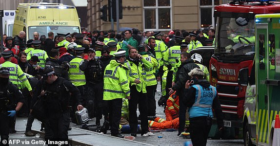 Members of the emergency services treat members of the public inside a Police cordon at the scene of an incident on Water Street, on the sidelines of an open-top bus victory parade for Liverpool's Premier League title win, in Liverpool, north-west England on May 26, 2025. (Photo by Darren Staples / AFP) (Photo by DARREN STAPLES/AFP via Getty Images)