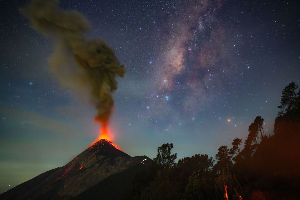Volcán Acatenango erupting at night under the Milky Way.