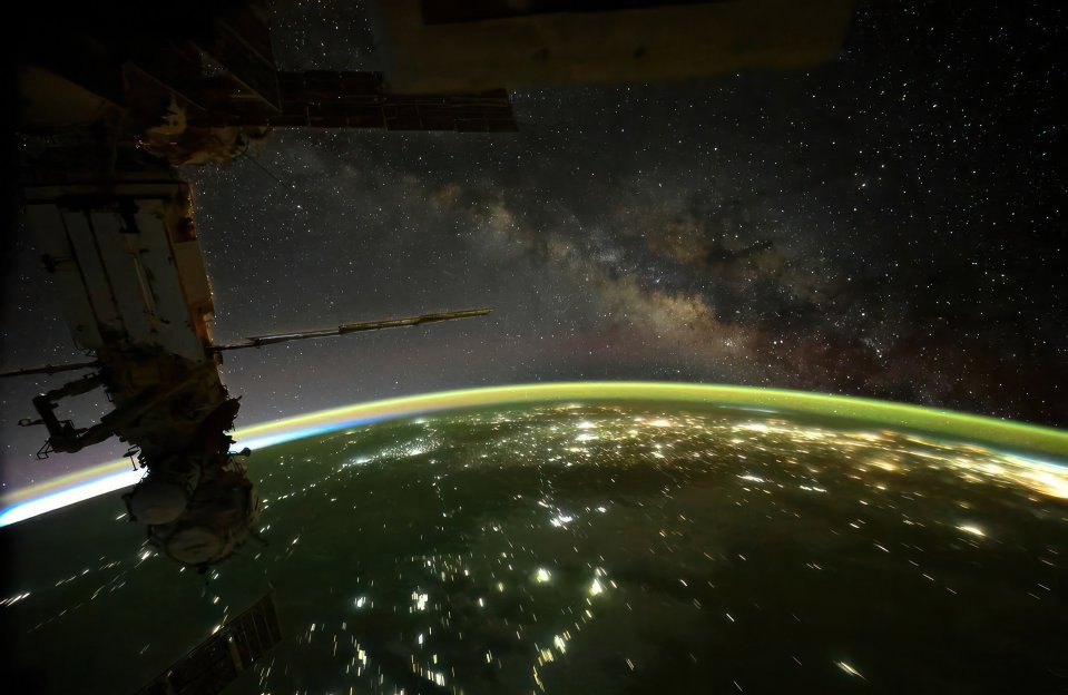 Milky Way viewed from the International Space Station, with Earth's horizon and city lights visible.