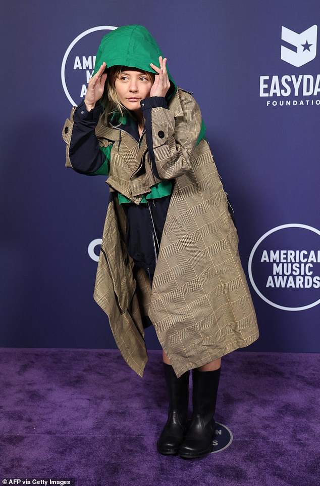 US singer and songwriter Dora Jar wore a bizarre green and brown rain jacket as well as some rain boots on the AMAs red carpet