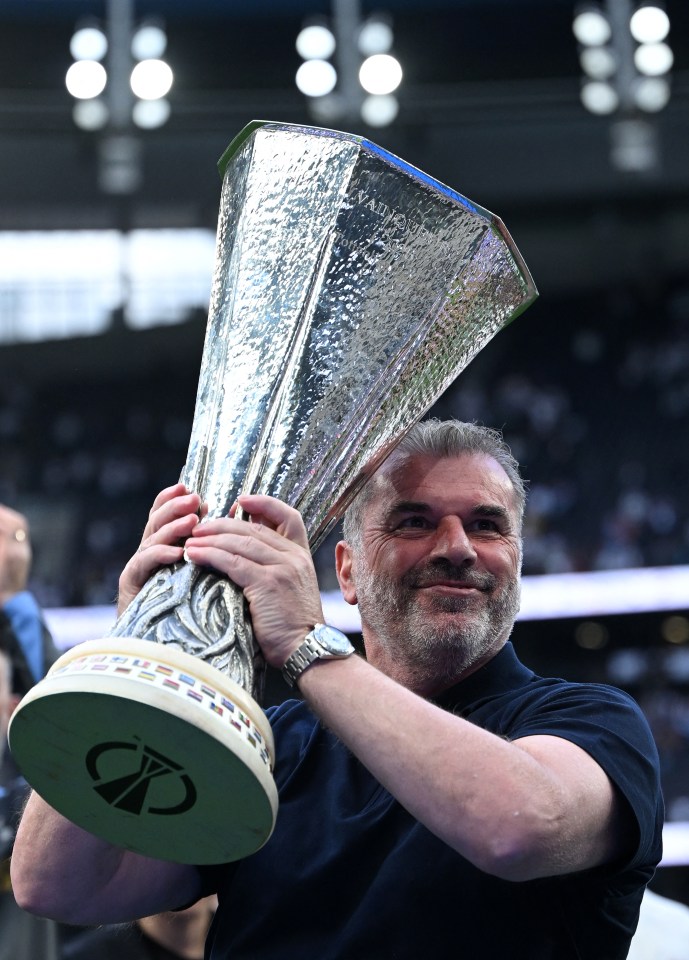 Ange Postecoglou holding the Europa League trophy.