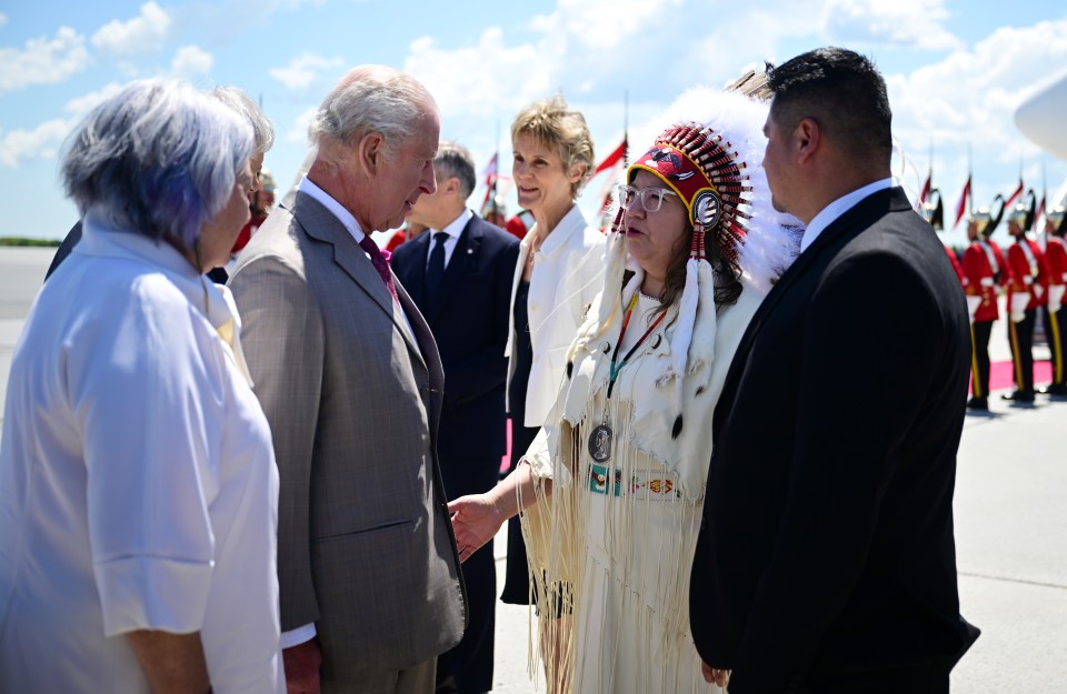 King Charles III and Queen Camilla meeting Indigenous people at an airport.