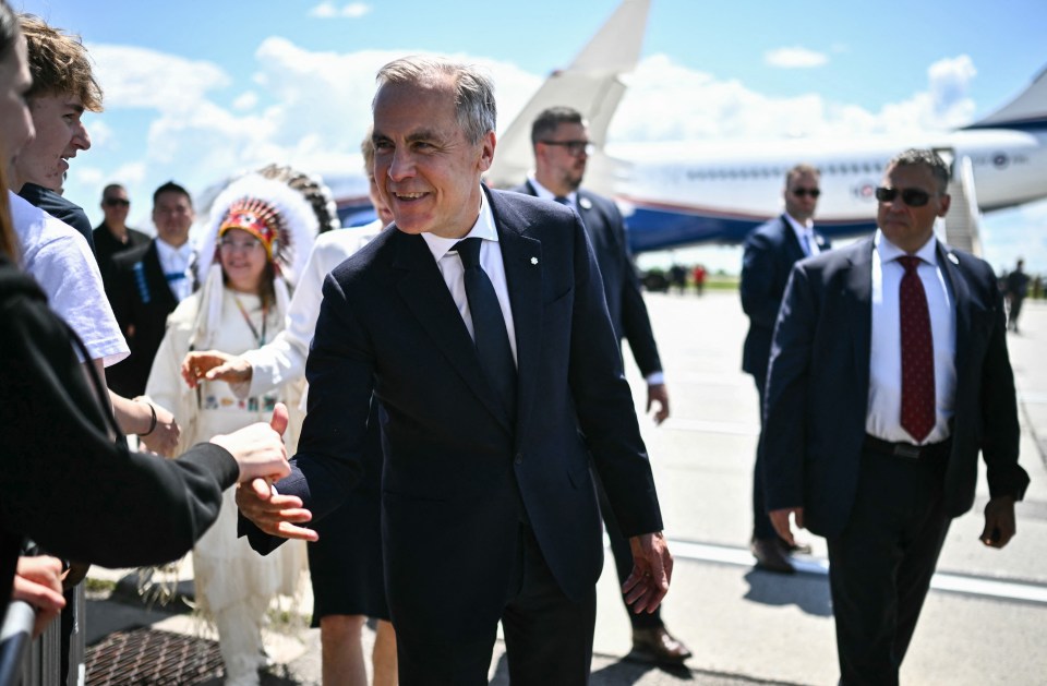 Canadian Prime Minister Mark Carney greeting people at an airport.