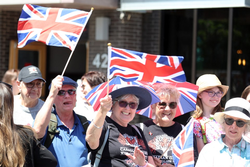 Well-wishers waving Union Jack flags at a royal event.