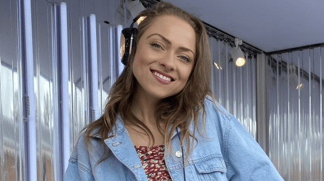 Sophie Wright, a writer, DJ, and former ice skater, wearing headphones and a denim jacket.