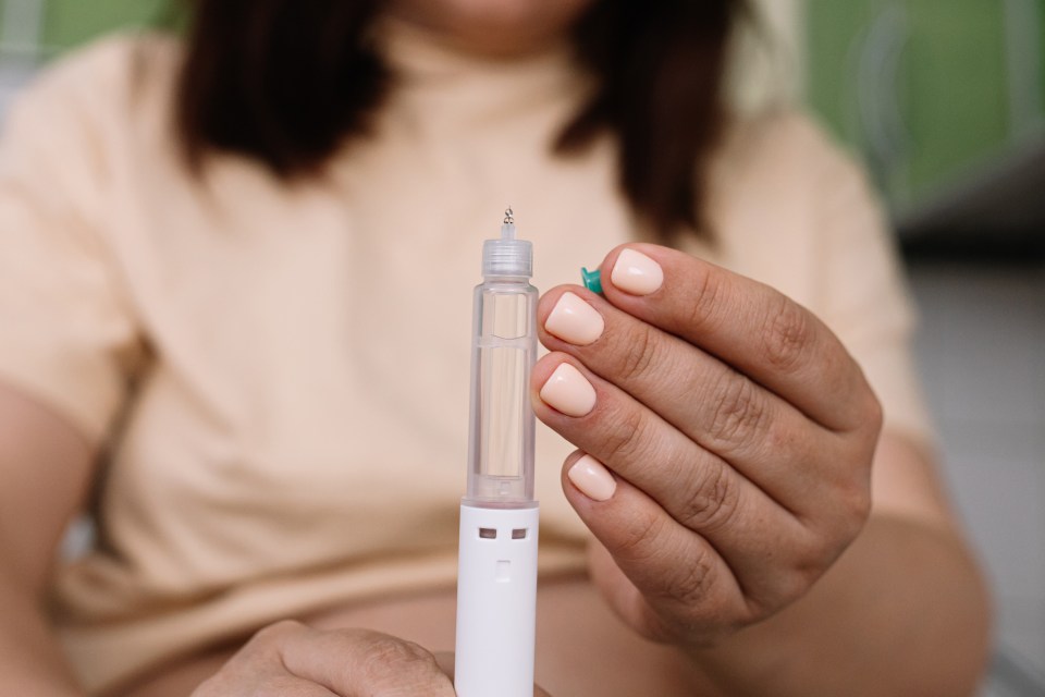 Woman's hands preparing a semaglutide injection pen.