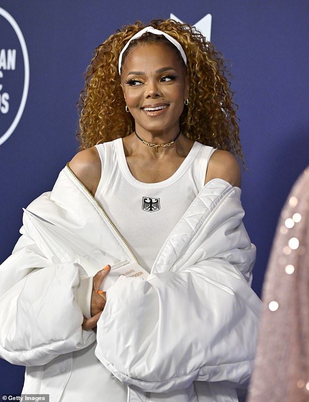 Her voluminous locks were partially pulled back away from her face with a thick white head band