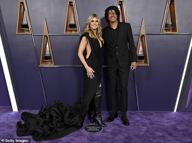 The star's son towered over his mother while sporting a classic black suit as well as a black dress shirt and sleek shoes