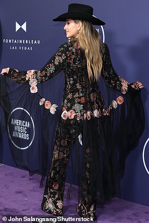 A sheer, black cape was added at the back of the blazer that also contained colorful floral details on the material