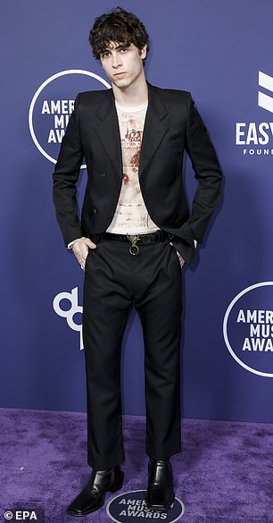 Musician Aiden Bissett was seen sporting a black blazer as well as black trousers and a printed white shirt