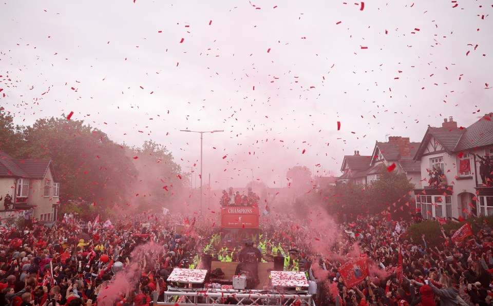 Liverpool players celebrate with fans in a victory parade.