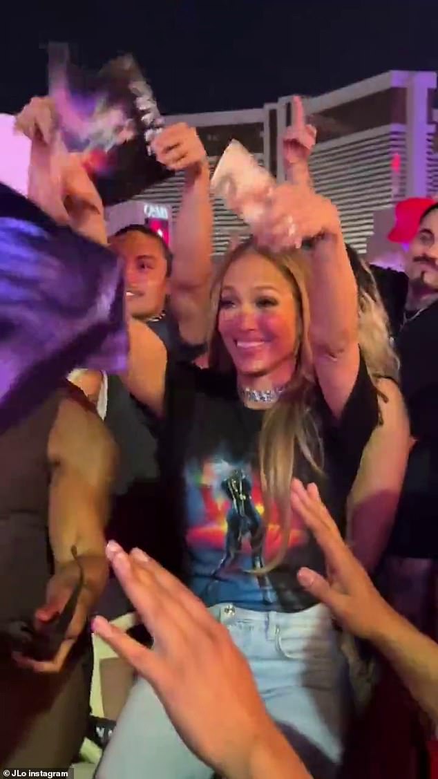 The singer and actress, who recently divorced ex husband Ben Affleck, was surrounded by men holding her up as she stood on a chair waving her arms in the air