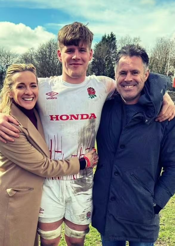 A woman and man embracing their muddy son in a rugby uniform.
