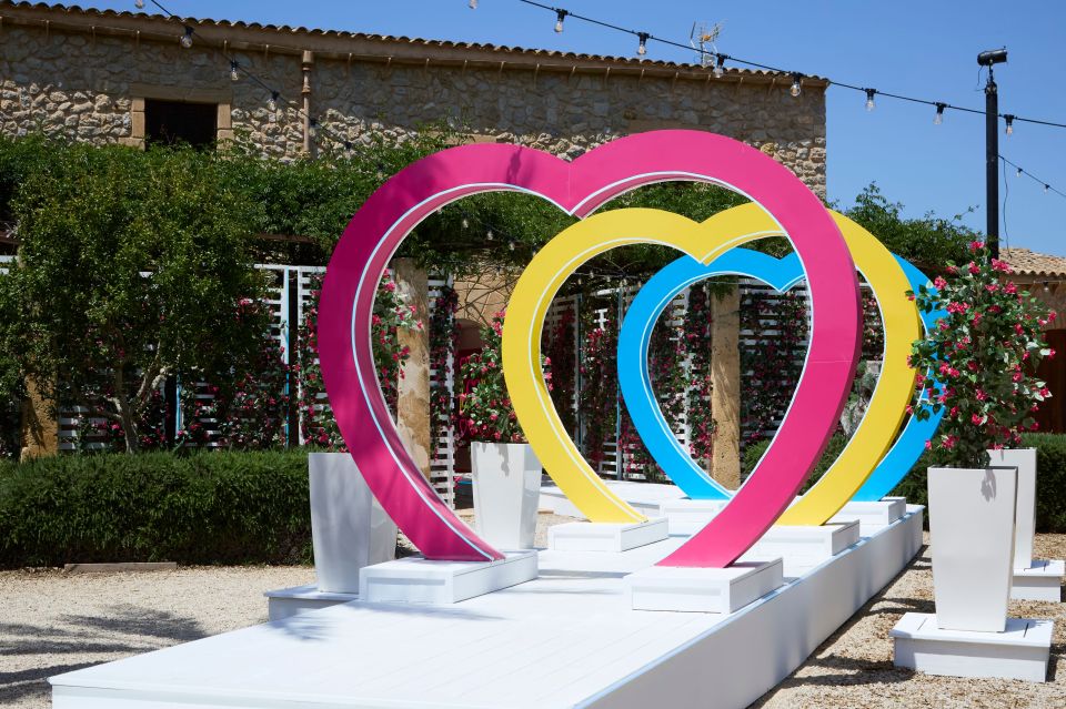 Love Island villa entrance with colorful heart-shaped arches.