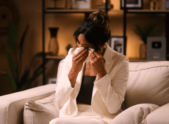 Woman crying while sitting on a couch.