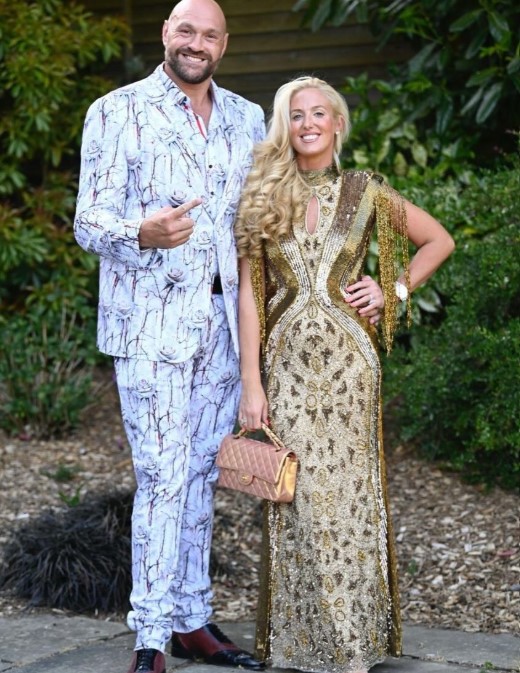 Tyson Fury and a woman in a gold dress at a party.