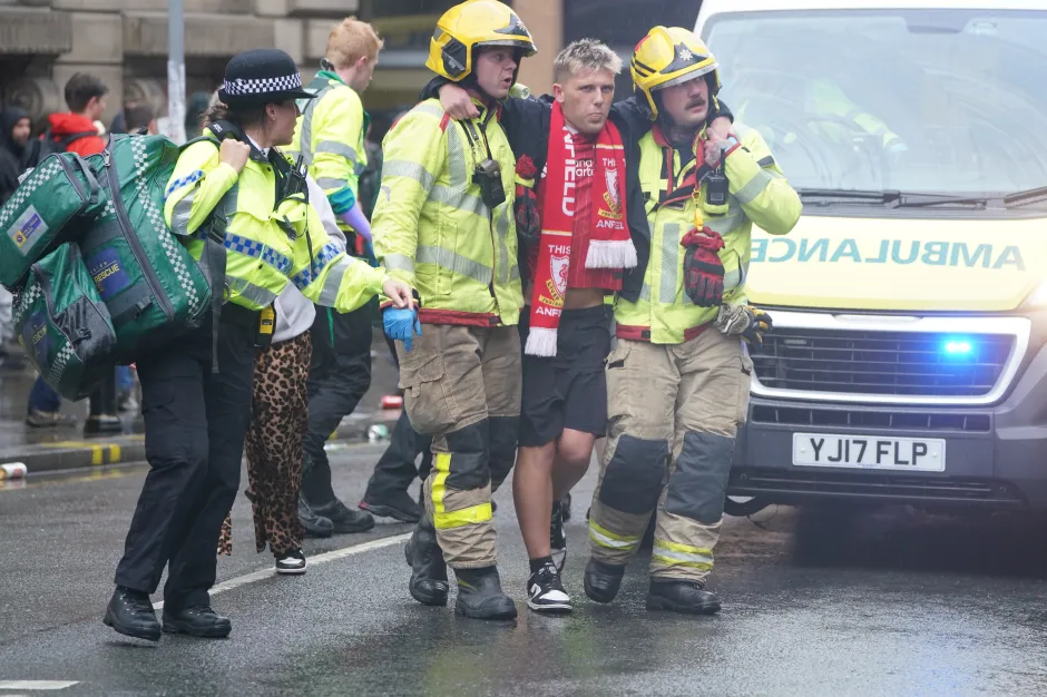 Two firefighters assisting an injured person.