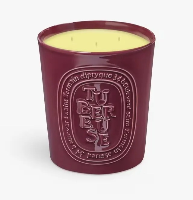 Diptyque Tubereuse candle in a burgundy jar.