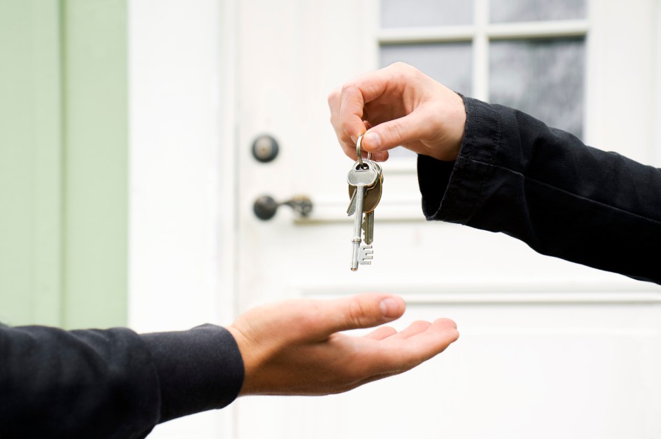 Two people exchanging house keys.