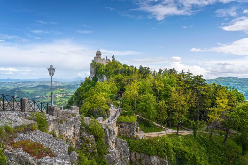 Medieval tower on a cliff overlooking a valley in San Marino.