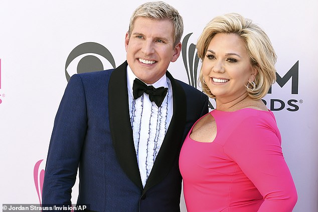 Todd Chrisley (left) and Julie Chrisley (right) wal a red carpet in 2017. The reality television couple was supposed to stay in jail until 2032 and 2028, respectively