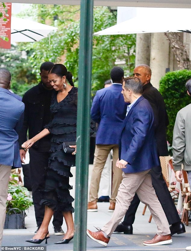 Barack Obama, right, can be seen casting a glance towards his wife, Michelle, as she makes her way to the couple's car