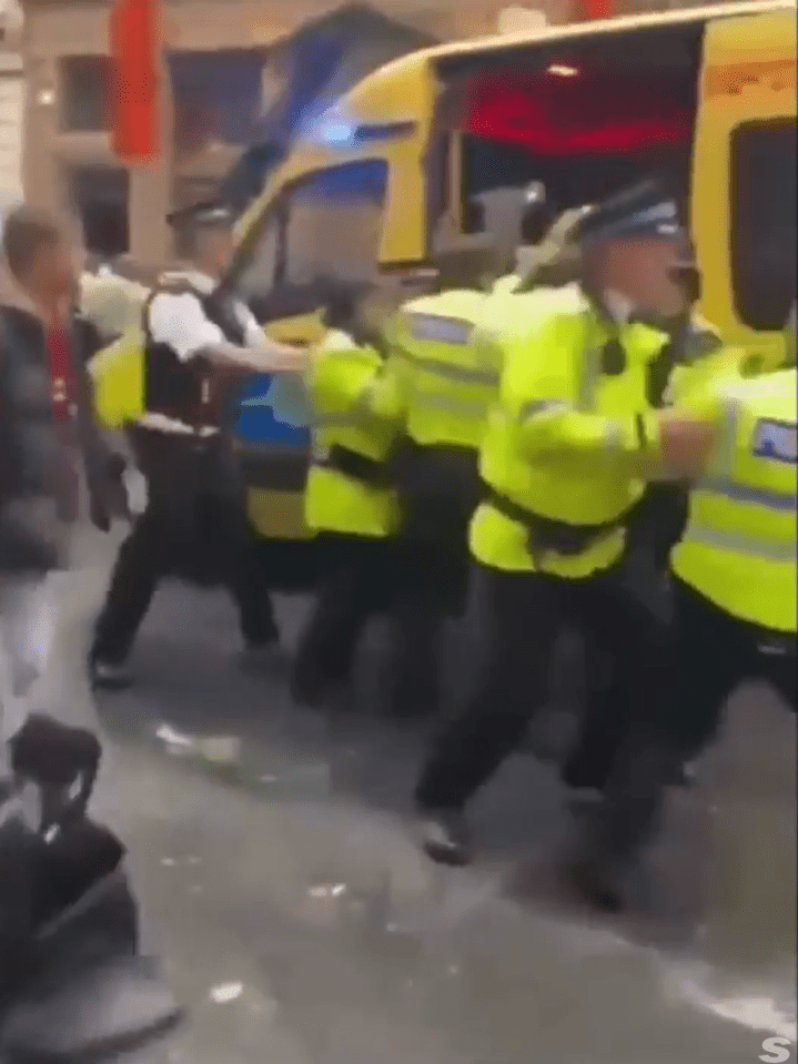 Police officers detaining a person.