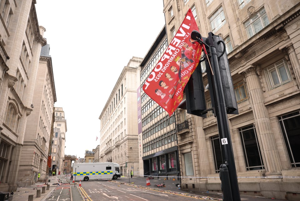 Debris-strewn street after a car collided with people during a Liverpool FC trophy parade.