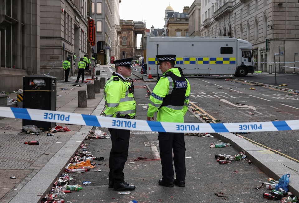 Police officers at the scene of an incident where a car hit a crowd.