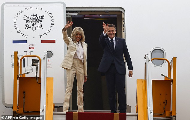 France's President Emmanuel Macron and his wife Brigitte Macron wave as they board their plane for departure following their visit to Vietnam