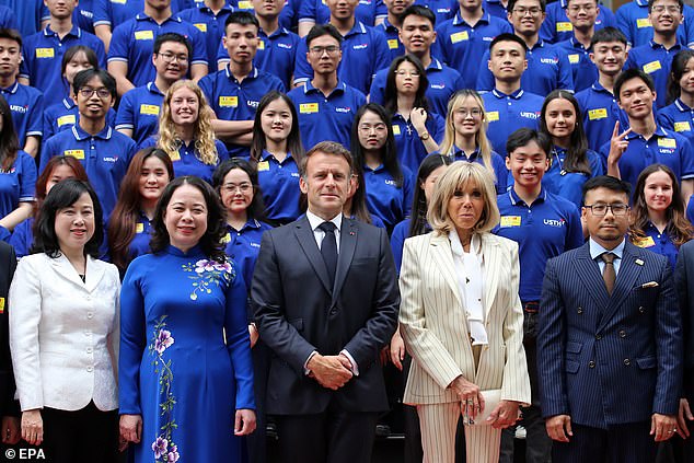 French President Emmanuel Macron (C) and his wife Brigitte Macron (2-R) and Vietnamese Vice President Vo Thi Anh Xuan (2-L) pose for a photo as they visit the University of Science and Technology of Hanoi