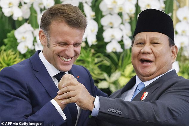 France's President Emmanuel Macron (L) and Indonesia's President Prabowo Subianto shake hands during a press briefing at Merdeka Palace in Jakarta on May 28